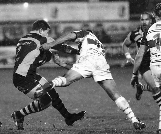 Darren carrying the ball in a competitive rugby match
